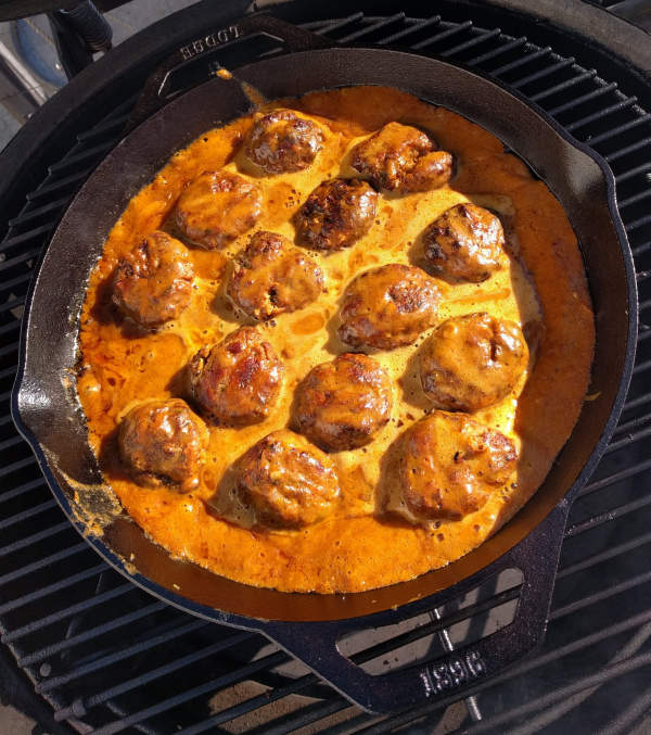 oconut curry pork meatballs simmering in a Lodge cast iron pan